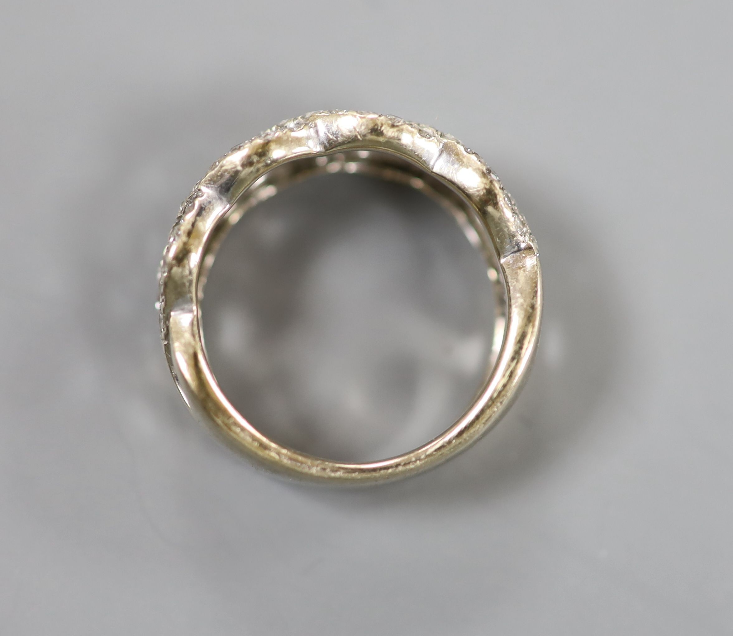 A modern 14k white metal and diamond chip set interwoven dress ring, size M, gross weight 6.5 grams.